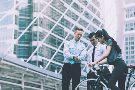 Business man is leading direction for a bicycle sport woman in cityの写真素材