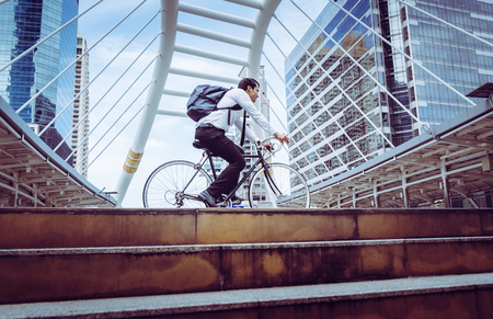 Healthy business man riding his bicycle to work in a modern cityの写真素材