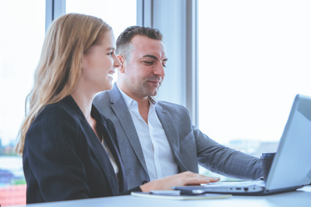 Boss and female worker is brainstorming on computerの写真素材