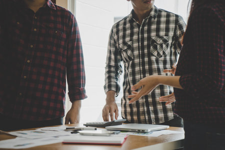 Casual business team is discussing report in meeting, no face