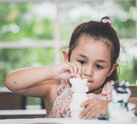 girl is painting a doll in Art classroomの写真素材