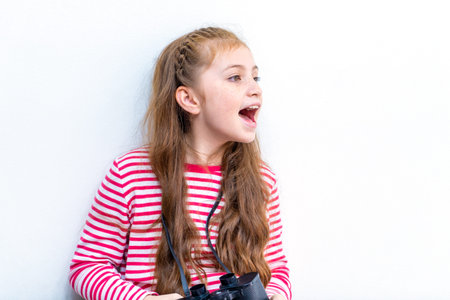 Little girl explorer is looking through binoculars