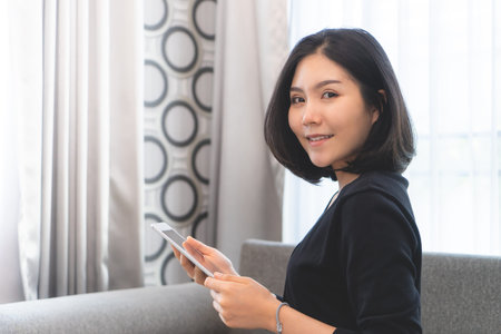 Attractive woman is using tablet on sofa