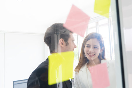 Business people is writing idea on to note paper for planning