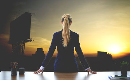 Female business woman is looking out the windows for successの写真素材