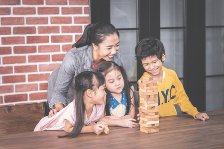 Teacher and students are building toy block tower togetherness classroomの写真素材