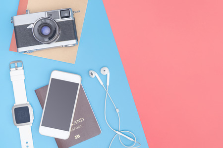 Travel top view gadgets and objects for business traveler on blue yellow pink copy spaceの写真素材