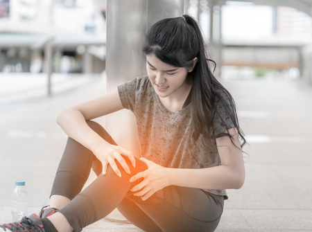 Sport woman is having an injury on her knee legsの写真素材