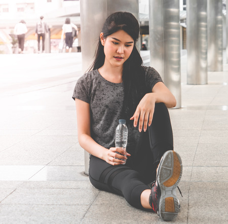 Sport Woman is drinking fresh water in hot outdoorの写真素材