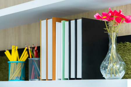 Classroom book shelf with books flower and pencilの写真素材