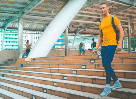 Male sport man is walking up the stair in modern city