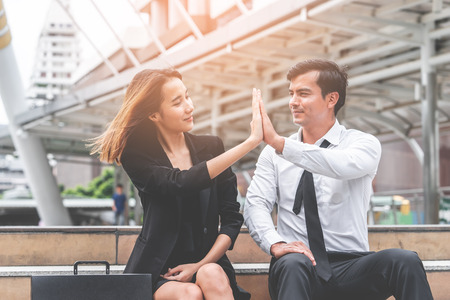 Business lover couple is hi five for success sitting outdoorの写真素材