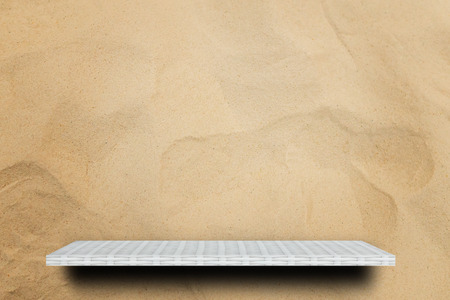 Empty white counter shelf on sand dune backgroundの写真素材