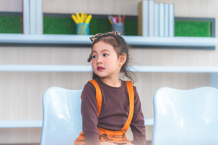 One little girl sitting in classroom aloneの写真素材