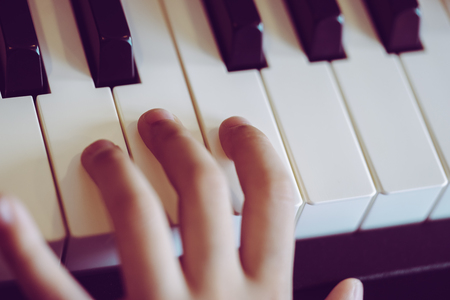 Close-up of a music Children's hand playing the pianoの写真素材