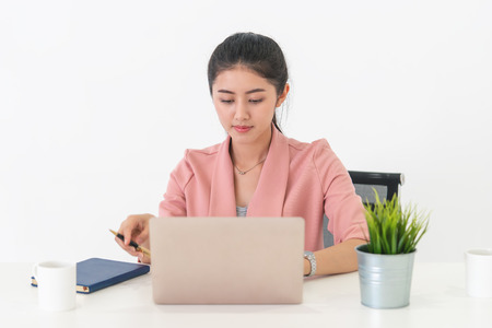 attractive asian businesswoman working on laptop in her office desk.の写真素材