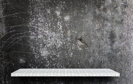 empty white shelf on dark cement wall for product displayの写真素材