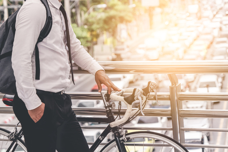 adult man on bike in the city in the morning with sun flareの写真素材