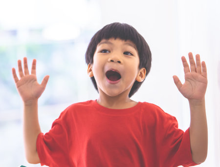 Funny boy in hand up and screaming at camera and shocked.の写真素材