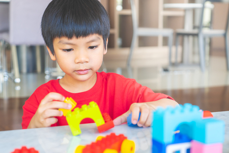 Happy boy stacking Toy blocks on a living room for educational toyの写真素材
