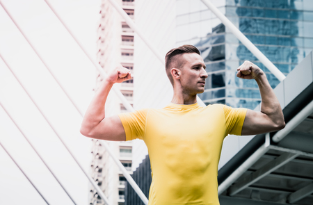 handsome strong athletic man with muscles in a yellow shirtの写真素材