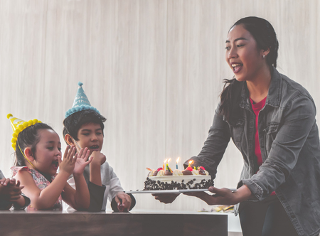 Group of children is blowing birthday cake in birthday  party singing happy birthdayの写真素材