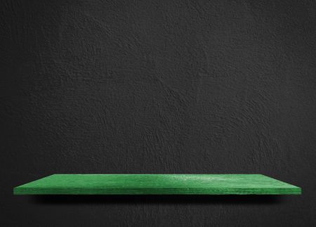 Empty green wooden shelf on black cement wallの写真素材
