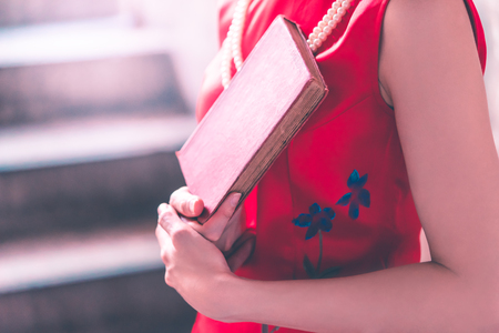 Red Asian woman holding a red book in her handの写真素材