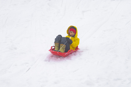 Little Japanese girl is sliding down the snow sled in Gala Yuzawa Ski resortの写真素材