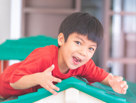 Funny boy in hand up and screaming at camera in playgroundの写真素材