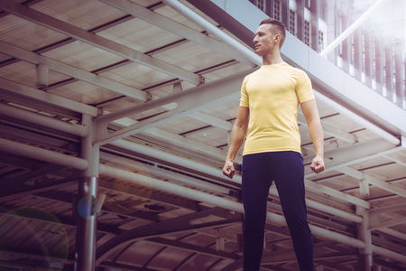 Sport man in yellow is standing in a modern city train stationの写真素材