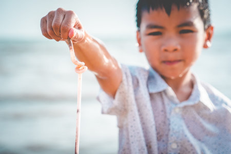 Children is holding Plastic straw that he found on the beach