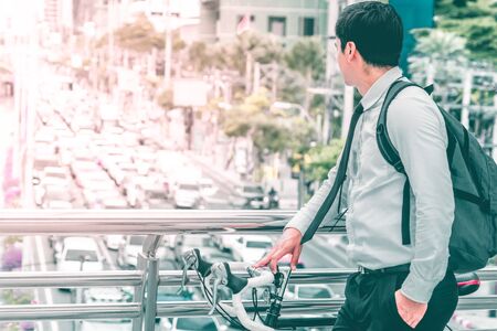 Modern Business man choosing to ride bike to work to avoid Bangkok traffic jamの写真素材