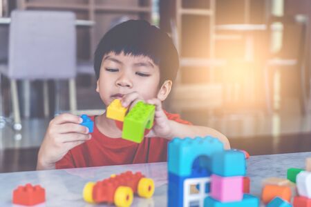 Happy boy stacking Toy blocks on a living room for educational toyの写真素材