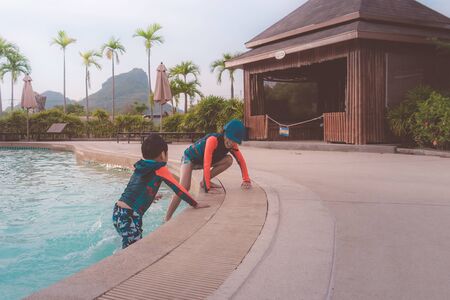 Two Asian siblings in playing together in Water Aqua park pool.の写真素材
