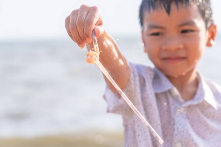 Children is holding Plastic straw that he found on the beach for enviromental clean up conceptの写真素材