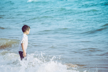 Little boy is playing with wave and sand on Pattaya beach