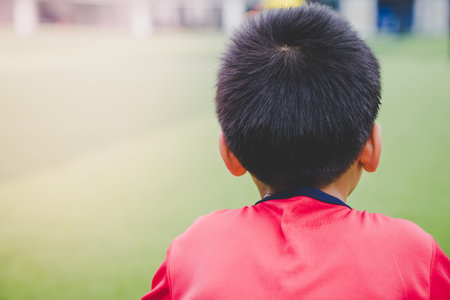 Little boy is relaxing in soccer training field