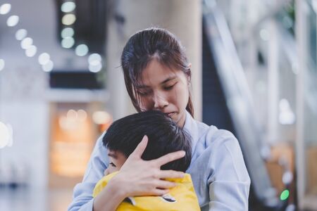 Mother is holding an upset boy closelyの写真素材