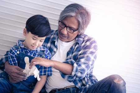 Builder father is Sitting next to his son for family connection concept in vintage tone