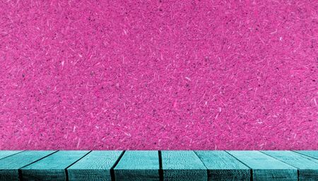 Teal wooden board display shelf table counter with copy space for advertising backdrop and background with pink plywood wall backgroundの写真素材