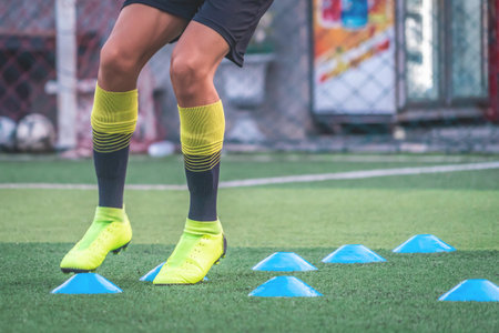 Soccer player feet is training with marker in soccer academy field