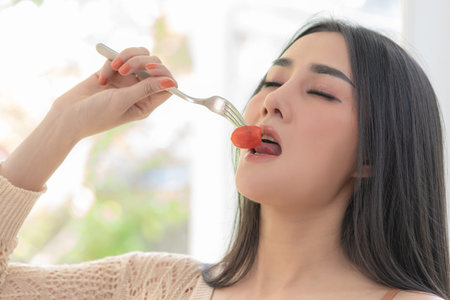 Healthy Sexy asian woman is eating red Tomato
