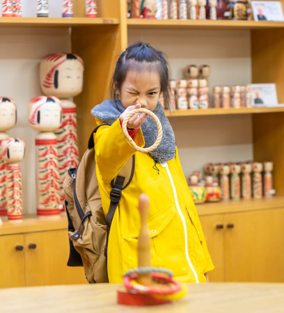 Little Asian girl is playing with hoop throwing gameの写真素材