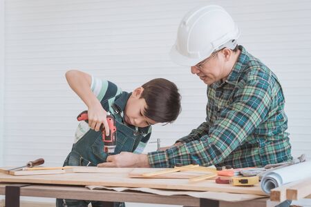 Father is teaching his son to fo the DIY home improvement work for parent and family bonding concept.の写真素材