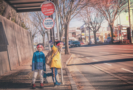 Sendai, Japan - 29 Dec 2019 : Two Japanese kids is waiting for school bus at Bus stop.のeditorial素材