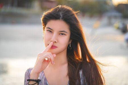 Beautiful woman is picking her nose using her finger spreading the virusの写真素材