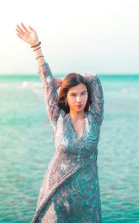 Beautiful Young Asian woman is relaxing on a blue Summer Beach for Summer Vacation Travel and...