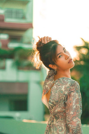 Woman portrait with hard sunflare on with Beach Resort on the background for Summer Beach relaxation...