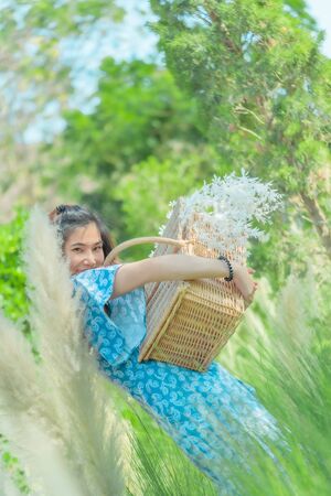 Beauty Farm lady Woman carrying a basket walking in agricultural field for carefree and healthy nature lifestyle concept.の写真素材